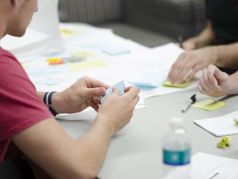 Team gathered around a table planning territory coverage with notes and sticky notes