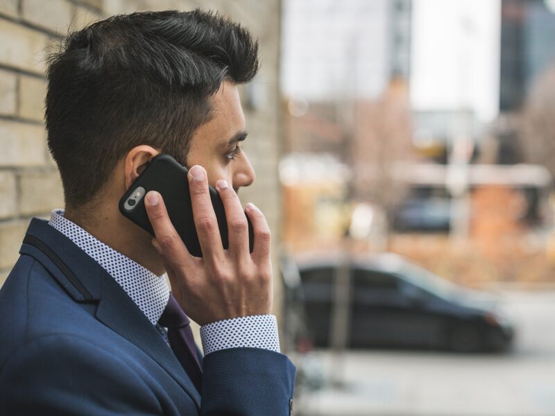 Businessman taking a phone call on a city street