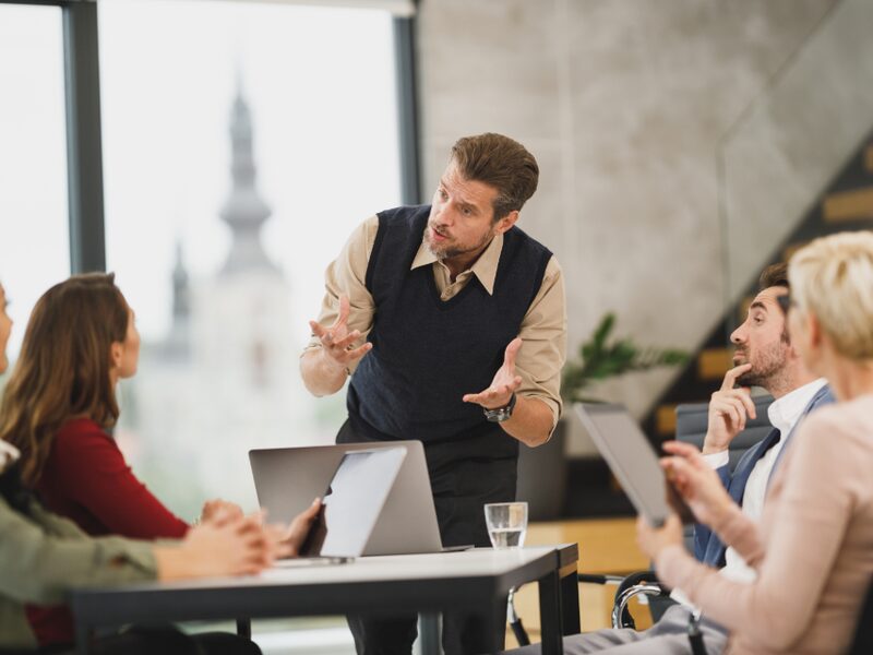 Trainer presenting to a seated group of sales representatives in a meeting room
